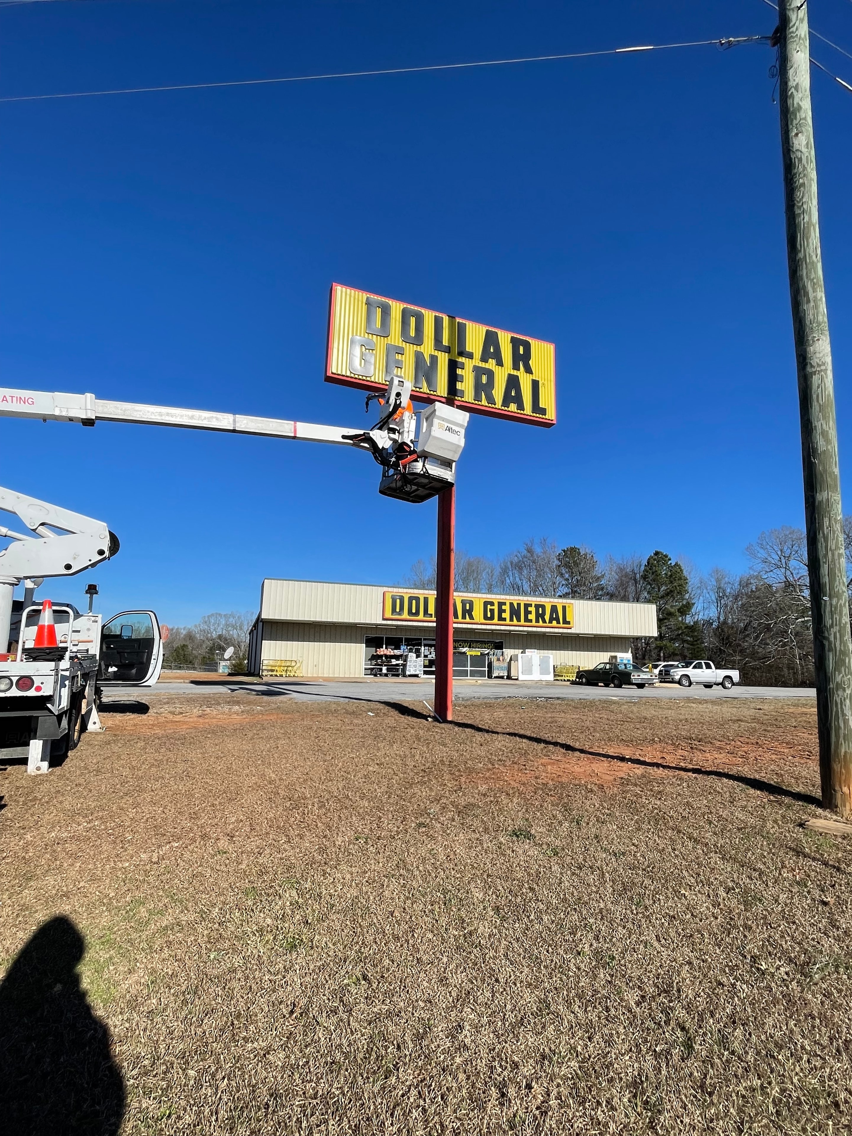 SOC technician performing sign maintenance on a Dollar General location
